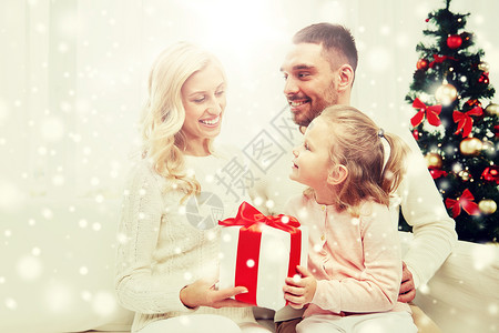 妈妈节艺术字家庭,诞节,假日人的快乐的母亲,父亲小女儿坐家里的沙发上幸福的家庭家里带着诞礼盒背景