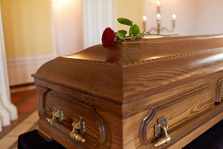 葬礼哀悼教堂木制棺材上的红玫瑰花教堂木制棺材上的红玫瑰花背景图片
