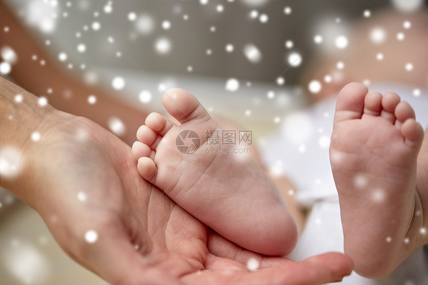 家庭,母亲,人儿童保育的新生儿的脚母亲手中的雪将新生婴儿的脚拢母亲手中图片