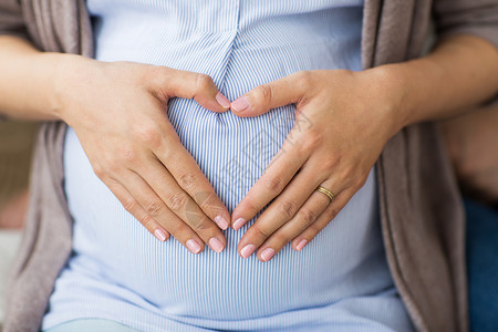 生育能力怀孕,爱人的密切孕妇手心肚子上靠近孕妇腹部心脏背景