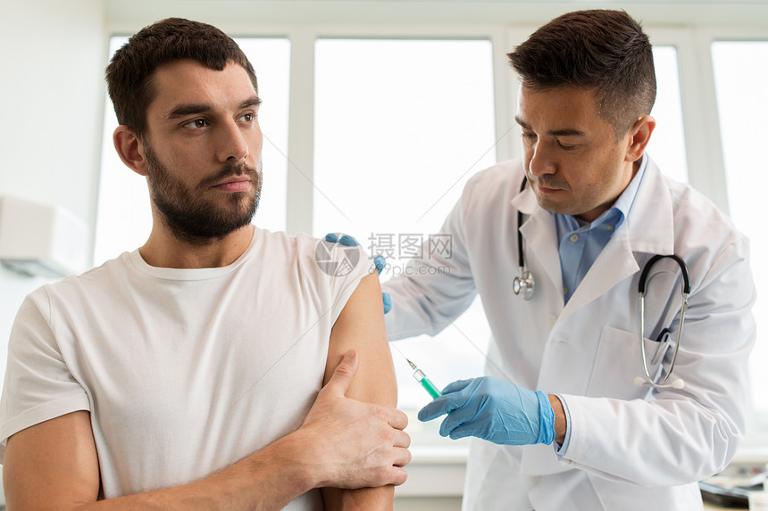 医学,疫苗接种保健医生用注射器给男病人注射疫苗病人医生用注射器进行疫苗接种图片