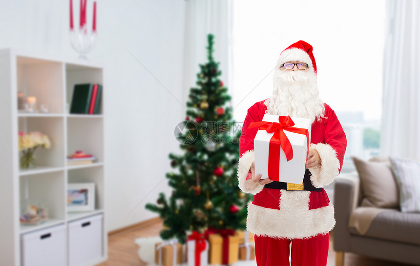 诞节,假日人的男人穿着诞老人的服装,家里的房间背景上礼品盒诞老人带着诞礼物家图片