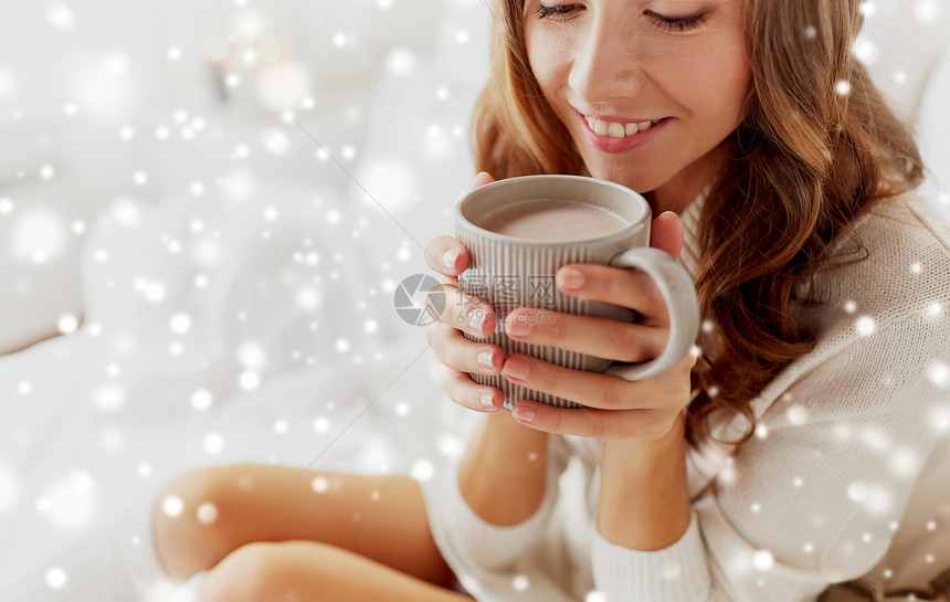 冬天,舒适,休闲人的靠近快乐的轻女人家里的雪上喝杯咖啡可可家喝杯可可的快乐女人图片