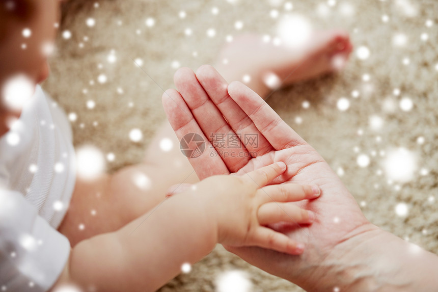 家庭,慈善人的亲密的小婴儿母亲的手雪把小宝宝妈妈的手关来图片