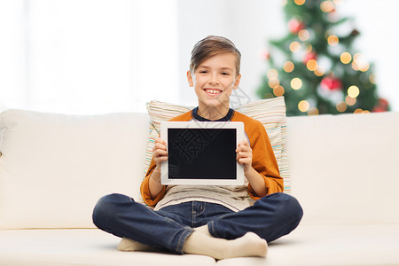 儿童,技术,广告人的微笑男孩与平板电脑家里的诞树背景微笑的男孩与平板电脑家里诞节背景图片