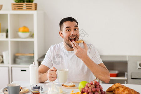 食物,健康的饮食人们的男人家里的厨房用咖啡早餐男人家里厨房用咖啡吃吐司图片