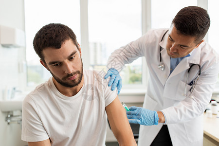 药物疫苗接种保健医生护士用注射器给男病人注射疫苗病人医生用注射器注射图片
