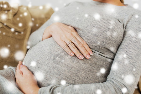 怀孕,人母亲的密切孕妇大腹便便家里下雪抱着大肚子的孕妇图片