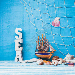 美丽的海洋成与玩具帆船,贝壳,璃瓶渔网蓝色背景图片