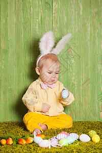 放孔明灯兔子小男孩像复活节兔子样草地上放着五颜六色的鸡蛋复活节兔子蹒跚学步背景