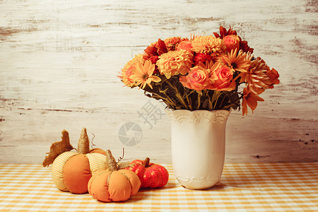 桌子上花小橙色纺南瓜的花瓶桌子上的秋天装饰高清图片