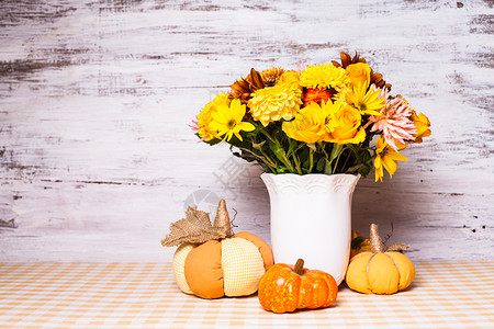 桌子上花小橙色纺南瓜的花瓶桌子上的秋天装饰高清图片