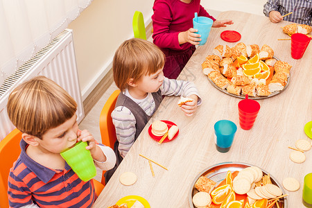 孩子们坐桌子旁吃午饭,吃水果蛋糕幼儿园吃午饭图片