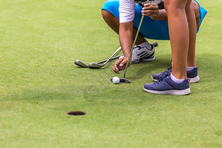 低段女高尔夫球员准备击球背景
