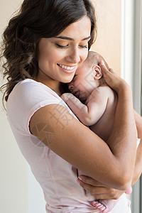 漂亮的女人抱着新生的婴儿背景图片