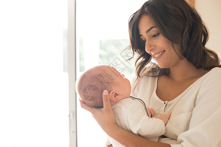 漂亮的女人抱着新生的婴儿背景图片