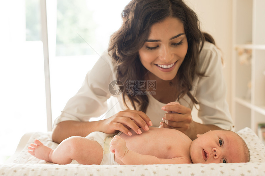 轻母亲洗澡后滋润婴儿的皮肤图片