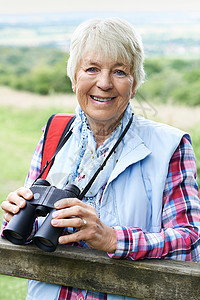 用望远镜走路的老年女子的肖像图片