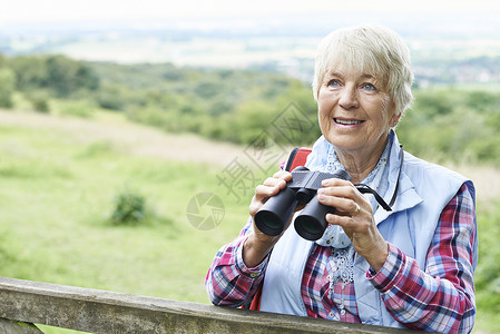 老妇女农村用望远镜走路图片