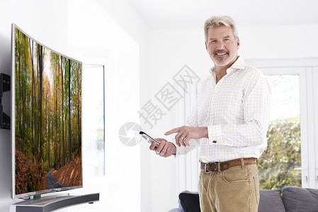 成熟的男人,家里新的弯曲屏幕电视图片