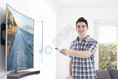 家里新的弯曲屏幕电视的轻人图片