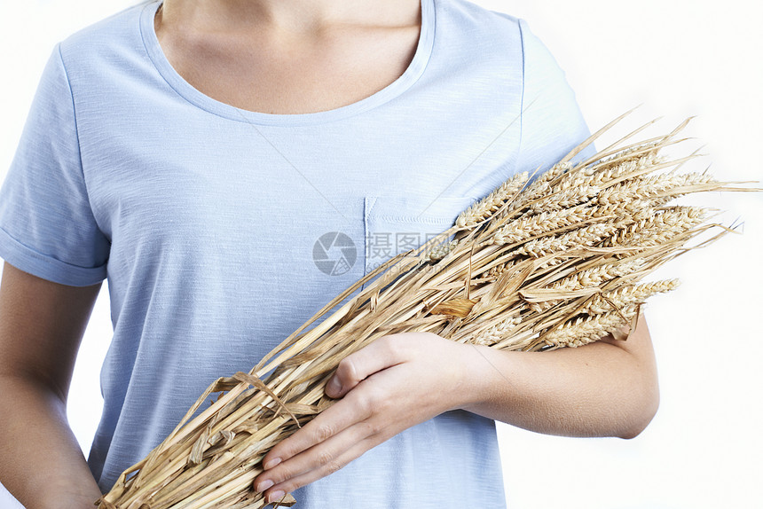 紧紧抱着捆小麦的女人图片