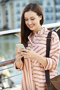 轻的女人手机上发短信走路上高清图片