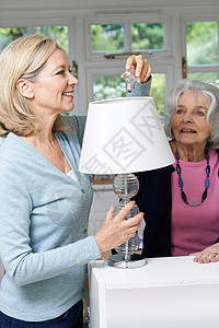 女邻居帮助老妇女更换灯泡图片