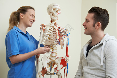 骨科医生用骨骼与病人讨论损伤图片