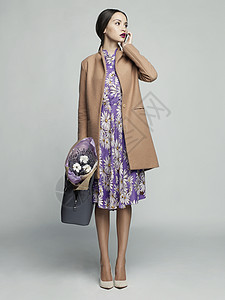 时尚工作室照片轻时尚的女人米色外套,薰衣草目录衣服看书图片
