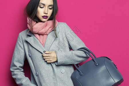 样书时尚工作室照片轻时尚的女人紫红色背景灰色外套,粉红色围巾,紫色口红,皮包,目录衣服配件看书背景