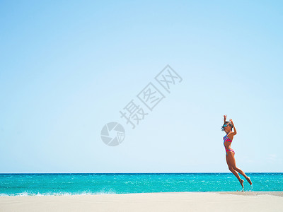 户外时尚照片美丽快乐苗条的女人跳海上海滩旅行夏天的气氛图片