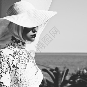 黑白花边分割黑白户外时尚照片,轻美丽的女士戴着白色帽子海上夏天的海滩旅行夏天的气氛背景