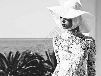 黑白户外时尚照片,轻美丽的女士戴着白色帽子海上夏天的海滩旅行夏天的气氛图片