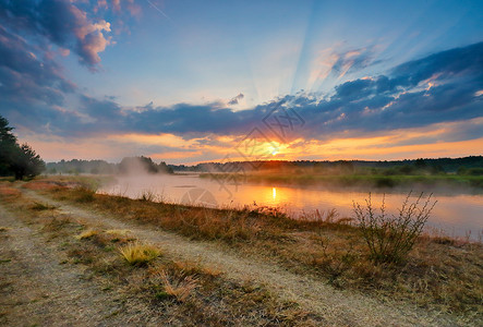 朦胧的夏日日出早上雾的河五彩缤纷的夏日早晨夏天早上河岸的土路背景图片