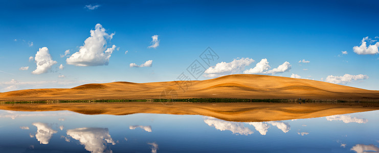 春天的田园风光,蓝天白云湖水中的倒影山上可耕地全景背景图片