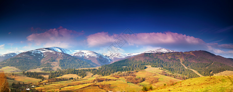春季雪山全景晨光中的山脉深蓝色的天空田园诗般的春天,高山晨景,背景中新鲜的绿色草地白雪皑皑的山顶背景图片
