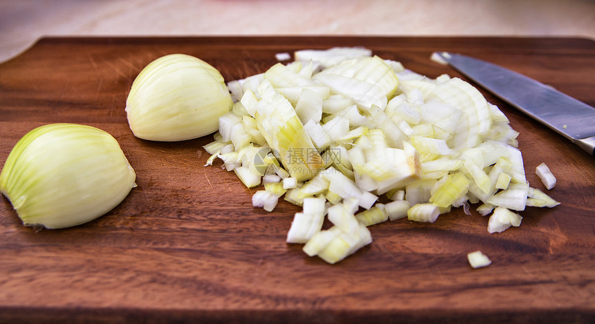 切洋葱砧板上准备饭菜木制切割板上切洋葱灯泡洋葱健康好处图片