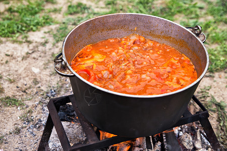 美味的匈牙利古拉什汤与辣椒牛肉大自然中的传统烹饪锅着火了背景图片