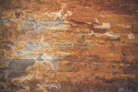 用橙色油漆剥落风化砖墙的旧墙图片