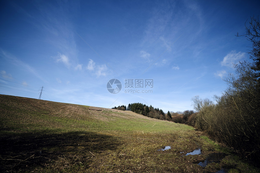 风景与山丘树木与蓝天塔田野的顶部图片