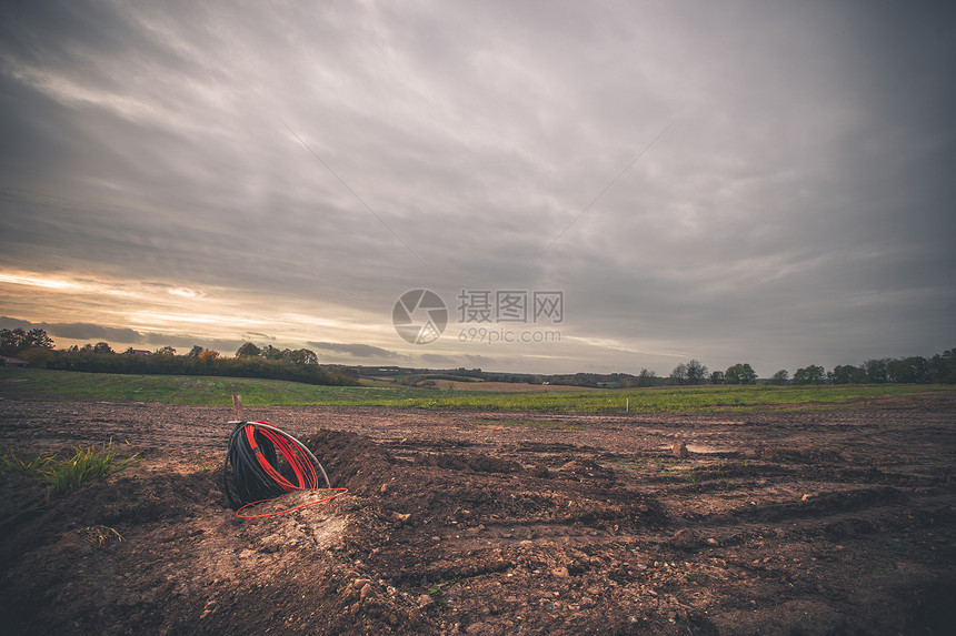 个空旷的建筑工地上的电线,泥土草,为建筑地上的新居民好了准备图片