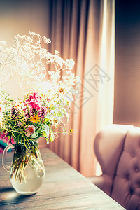 花瓶里的花窗边的桌子上,舒适的家庭内部图片