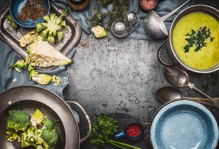绿色罗曼斯科西兰花汤与烹饪原料,厨房工具,勺子,碗勺子黑暗的乡村背景,顶部视图,框架健康素食饮食营养图片