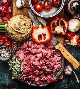 生肠肉与菜刀新鲜蔬菜,调味料香料,美味烹饪黑暗的乡村背景,顶部视图图片