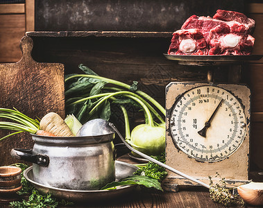 厨房餐桌上煮锅勺子蔬菜生肉的旧秤,准备汤肉汤炖观看乡村风格图片