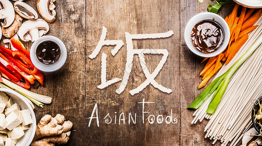 亚洲食品与各种蔬菜烹饪原料木制背景与中国象形文字的食物,顶部视图,横幅图片