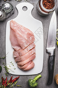 生鸡胸片白色切割板与菜刀食材烹饪,顶部视图,背景