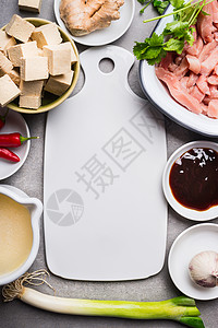 亚洲汤配料与豆腐丁肉片周围空白白色切割板,顶部视图图片