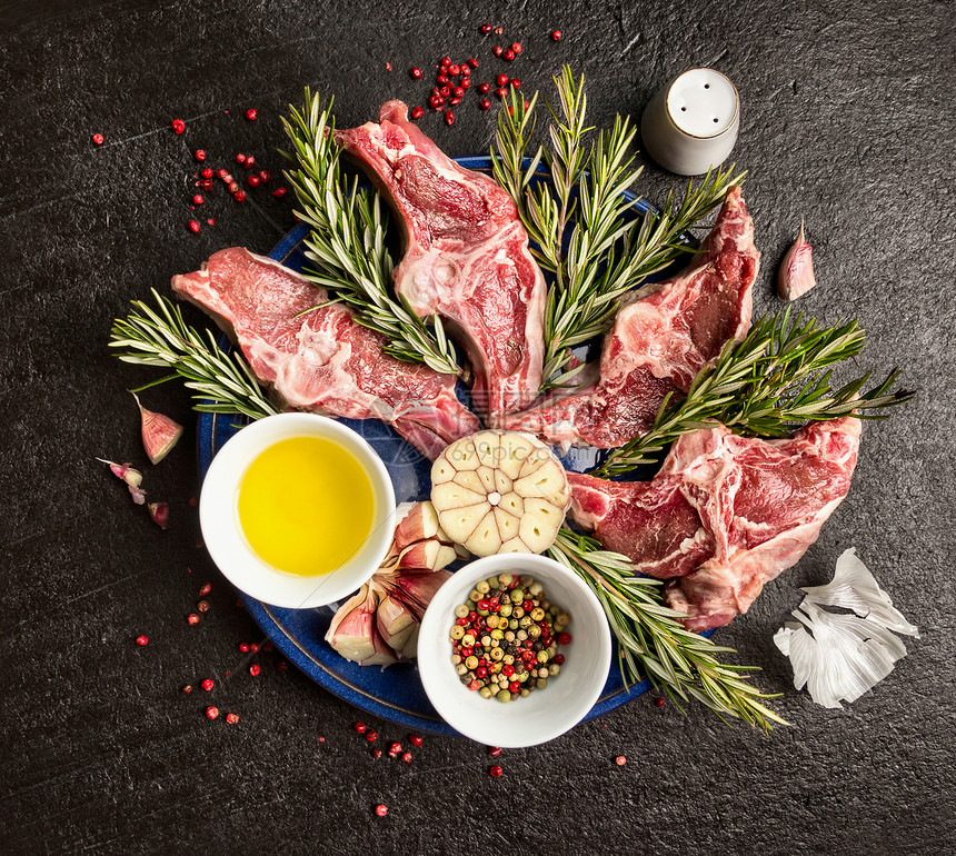 羊肉与油,草药香料黑暗的背景,顶部视图图片